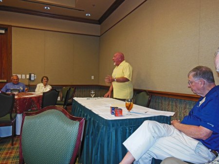 Bill Heath speaks; Bob Dorrill (foreground) and others listen.